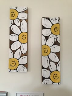 two wall hangings with yellow and white flowers on them