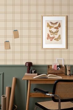 a chair and desk in a room with wallpaper on the walls, papers scattered about