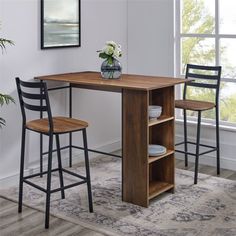 a wooden table with two chairs and a vase on it next to an open shelf