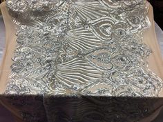 the table is covered with an intricate silver cloth