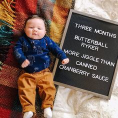 a baby laying next to a sign that says three months butterball ryer more juggle than cranberry sauce