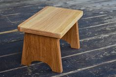 a small wooden stool sitting on top of a wooden floor