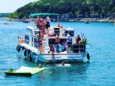 a group of people standing on top of a boat in the water