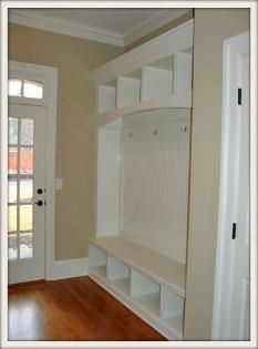 an empty room is shown with the door open and shelving on the wall next to it