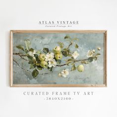 an apple tree branch with white flowers and green leaves is featured in this framed art piece