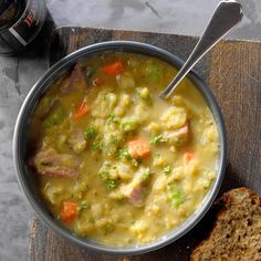 a bowl filled with soup next to a slice of bread