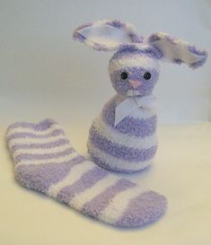 a stuffed animal bunny sitting next to a pair of striped socks