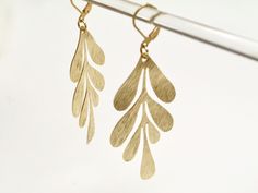 A large golden floral earrings inspired on Matisse leaf. To shine! Made with brass, polished to be smooth and shinny, brass earrings. I hand make each piece in my studio in Barcelona and no two are alike. This jewelry is handmade and slight imperfections are part of the character of the piece. Raw brass will patina (deepen in color) over time. Brass pieces can be restored to its original bright gold brass color by simply rubbing the piece with a jewelry polishing cloth, any other commercial bras Evening Gold-tone Brass Earrings, Matisse Leaf, Gold Brass Flower-shaped Earrings, Gold Leaf-shaped Brass Jewelry, Elegant Leaf-shaped Brass Earrings, Bohemian Leaf-shaped Brass Jewelry, Floral Jewelry, Tropical Leaf, Gold Flakes