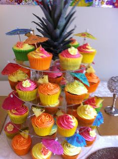 cupcakes are stacked on top of each other with pineapple in the background