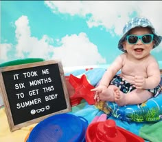 a baby wearing sunglasses sitting on top of a blue and green blanket