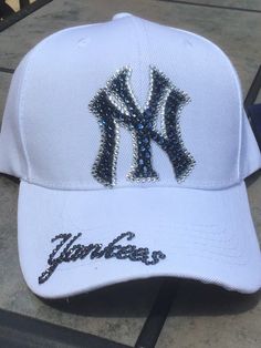 Check out these Ahhhhh-mazing Yankees hatsembellished with 100% authentic Swarovski crystal rhinestones These hats are a classic style ladies cut/fit, and have an adjustable velcro strap across the back. Choice of white or any colored hat. The white hat has navy blue stones with clear outline and the Yankees on the brim. The navy hat is made with all clear crystal and Yankees on the side of the hat I custom make these hats, and I can make them in just about any style or color combo. Please feel Rhinestone Baseball Cap One Size, Rhinestone Embellished One Size Baseball Cap, White Hats With Rhinestones And Curved Brim, Adjustable Baseball Cap With Bling, White Rhinestone Hat With Curved Brim, Adjustable Rhinestone Baseball Cap With Curved Brim, Adjustable Rhinestone Cap, Decorative Hats, Ig Fits