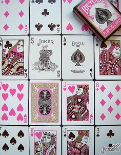 playing cards are arranged on top of each other with pink and gold designs, including spades