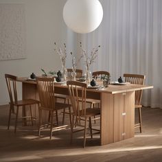 a dining room table with chairs and vases on it