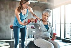 an older woman is exercising with a trainer