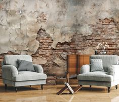 two chairs and a table in front of a brick wall with peeling paint on it