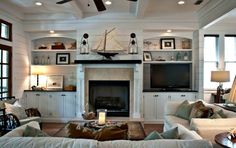 a living room filled with furniture and a flat screen tv mounted on the wall above a fire place