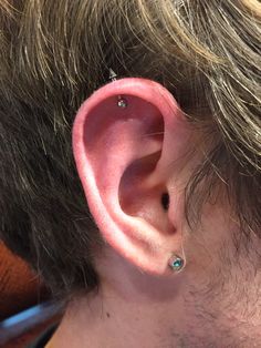 a close up of a person with an ear piercing on their left side of the ear