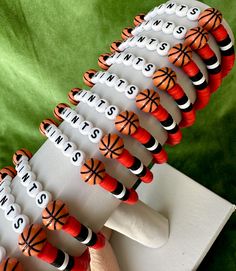 the toothbrush holders are decorated with orange and black designs on white sticks, which spell out dentists