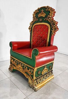 a red and green chair sitting on top of a tile floor next to a white wall