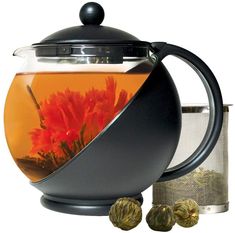 a tea pot filled with water and flowers