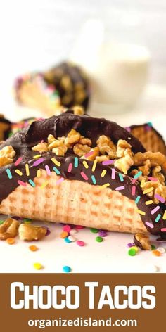 chocolate tacos with sprinkles and nuts on top, sitting on a plate