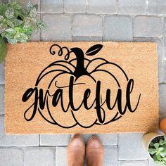 a door mat with the word grateful written on it next to potted plants and eggs