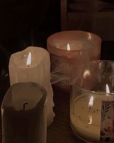 three lit candles sitting on top of a wooden table