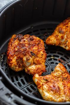 three pieces of chicken cooking in an air fryer