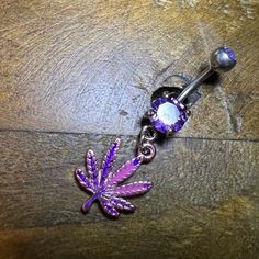 a purple jeweled belly ring with a flower on it