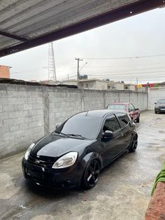 a small black car parked in a parking lot