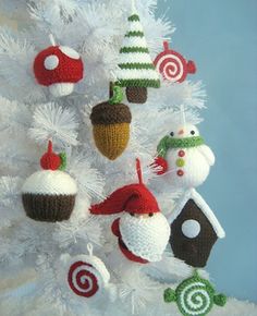 a white christmas tree decorated with knitted ornaments