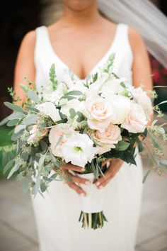 a bride holding a bouquet of flowers in her hands