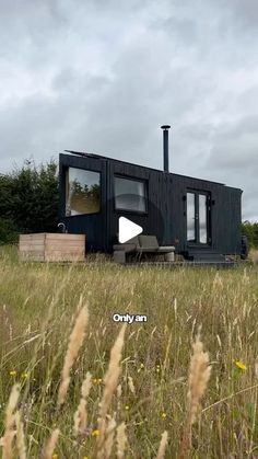 the tiny house is sitting in tall grass