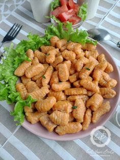 a white plate topped with chicken and lettuce next to a cup of milk