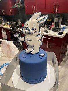 a blue cake with a white rabbit on top