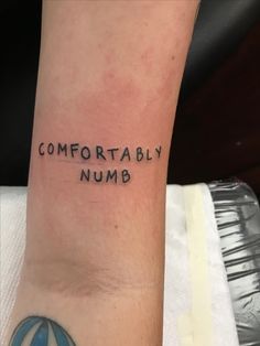 a person with a tattoo on their arm that says comfortably numb