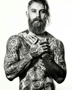 a man with lots of tattoos on his chest and arms is standing in front of a white background