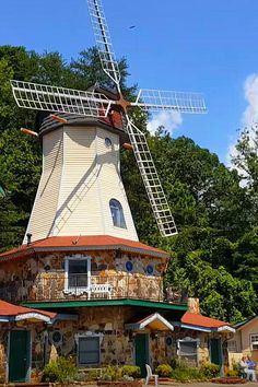 a windmill shaped building sitting in front of trees