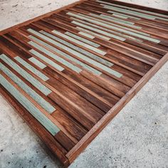 a close up of a wooden bed frame on the ground with no people around it