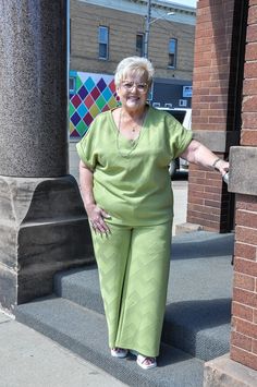 an older woman is standing on some steps