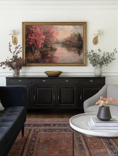 a living room filled with furniture and a painting on the wall