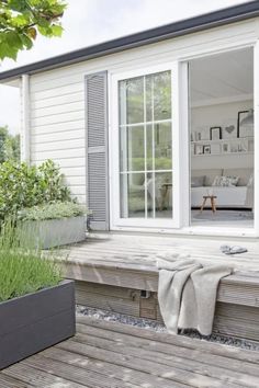 a white house with wooden decking and windows