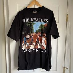 the beatles t - shirt hanging on a door