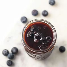 a jar filled with blueberries sitting on top of a table