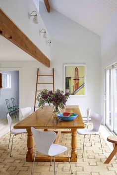 a wooden table with white chairs in a room