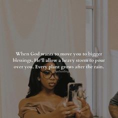 a woman looking at her cell phone while sitting in front of a mirror with the caption when god wants to move you to bigger belongs, he'll allow a heavy storm to pour over