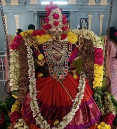 the statue is decorated with flowers and garlands