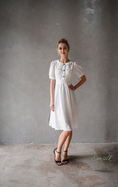 "This design linen dress is perfect for summer and fall! 100 % designed and handmade by Emsilk. I am pleased to offer your garments made to measure at no extra cost. * Detail: - Collared neckline - Coconut buttons on the front - Small gathered decoration on the front - Fit and flare bottom - Fully lined - Invisible zipper on the back - Below the knee length - High quality linen, washed linen, soft linen - The model is 5'6\" tall and wearing size S. * Care: - Dry clean or machine washed with cold Flowy Dresses With Gathered Sleeves And Short Sleeve, Flowy Dresses With Gathered Short Sleeves, Fitted Linen Dress For Garden Party, White Short Sleeve Vintage Dress For Summer, Summer White Vintage Dress With Short Sleeves, White Puff Sleeve Vintage Dress For Summer, White Short Sleeve Vintage Summer Dress, White Vintage Dress With Short Sleeves For Summer, Fitted Short Sleeve Dress For Summer Garden Party