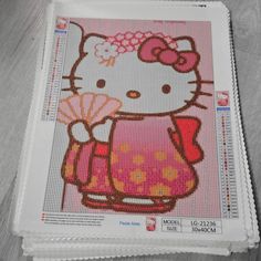 a hello kitty cross stitch pattern on top of a table