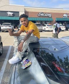 a man sitting on the hood of a car